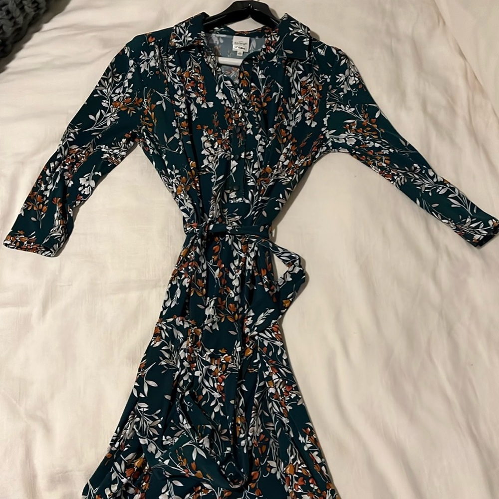 Knee length green dress with tied waist. Button down top. Floral design.